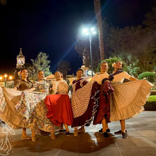 Bailarinas con faldas amplias abiertas en una plaza de noche