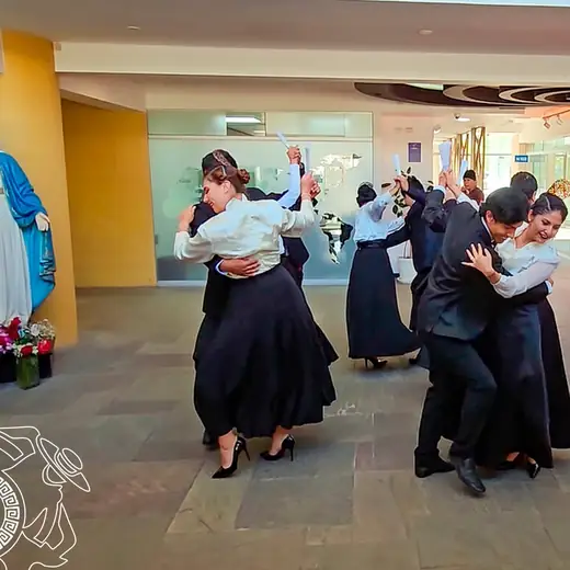 Parejas de baile en un vestíbulo, junto a una estatua