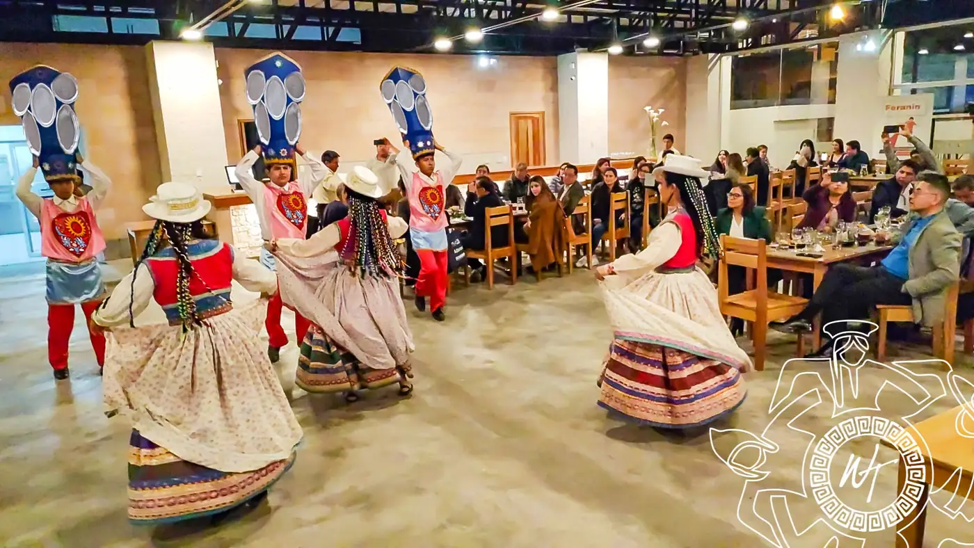 Danza con máscaras y trajes andinos durante una cena con público